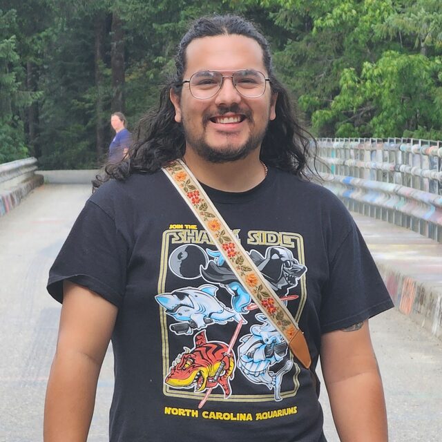 Josh wearing a shark-themed t-shirt on a bridge
